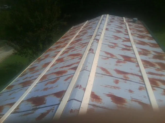 Rusted metal roof panels with new wood purlins before replacement — Storm Damage Roof Repair in Leota by Roofing Brothers