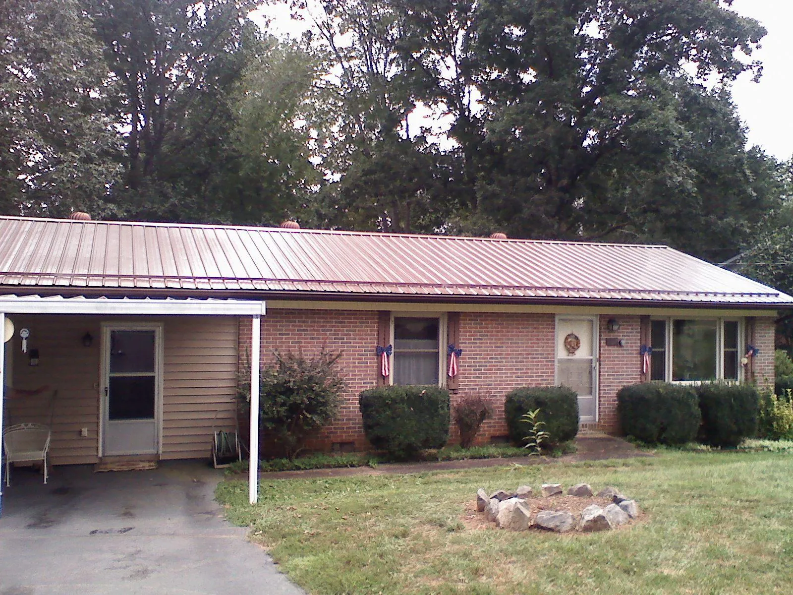 Bronze metal roof and carport on a brick ranch home — Roof Repair work by our crew in Leota